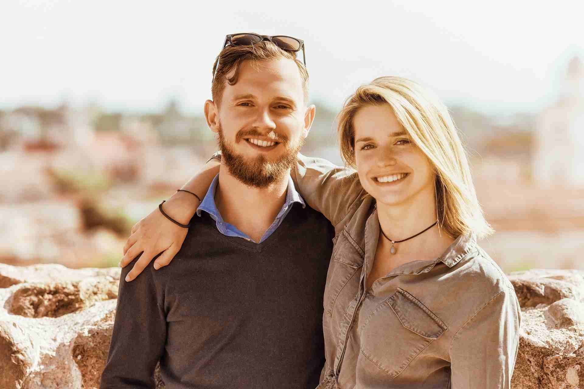 Smiling couple standing together outdoors showing emotional support and connection