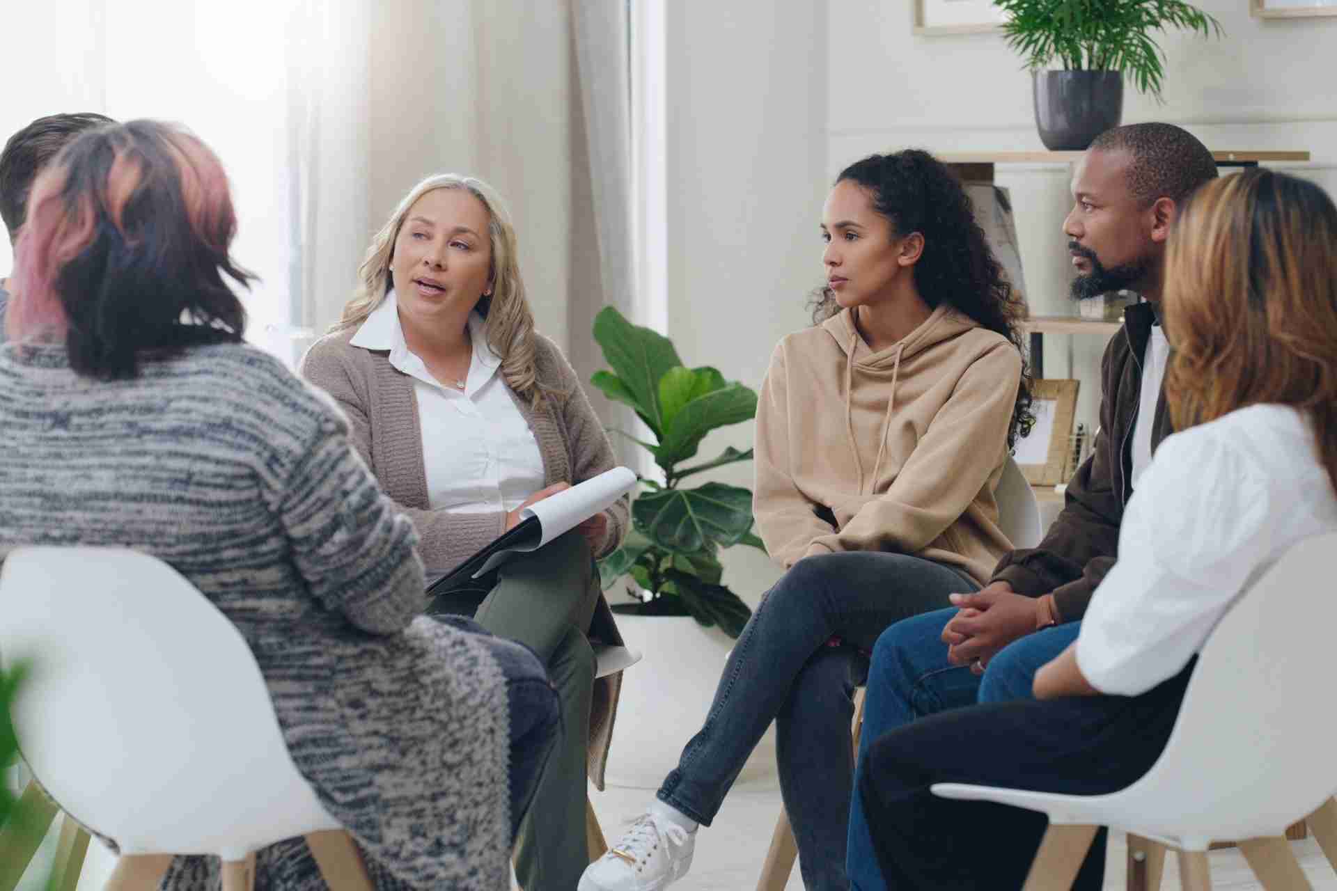 Group therapy session in an intensive outpatient program with clients participating in a guided discussion